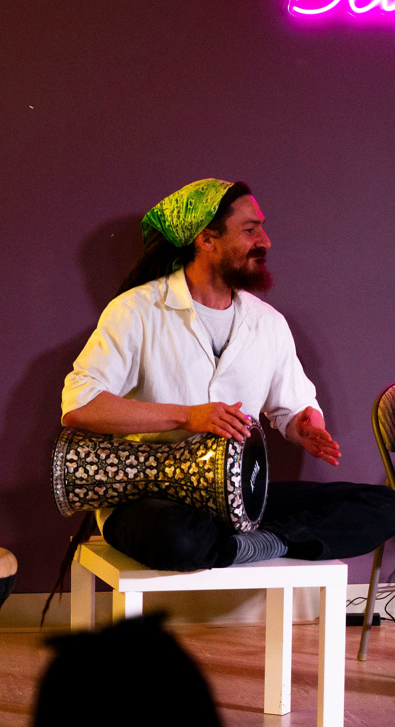 Theo Hunt playing Darbuka on a chair